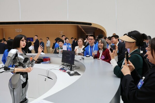 Visitors interact with a humanoid robot at the opening of the 2024 Zhongguancun Forum in Beijing on Thursday. [Photo by WANG ZHUANGFEI CHINA DAILY]